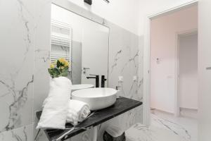 a white bathroom with a sink and a mirror at Re di Roma Rooftop in Rome