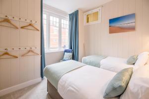 a bedroom with two beds and a window at No 12 Southwold in Southwold