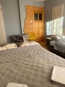 a bedroom with a bed and a yellow chair at Domek Okno na Tatry - Dom na wyłączność in Poronin