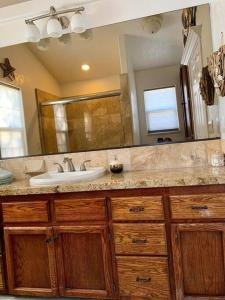 uma casa de banho com um lavatório e um espelho grande em Beautiful and Relaxing Guest House!! em Redding