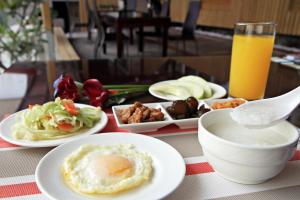 Beauty Garden Hotel - Jiaoxi في جياوكسي: طاولة مع أطباق من الطعام على طاولة مع عصير البرتقال