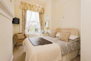 1 dormitorio con cama y ventana en The Daylesford Guest House, en Torquay