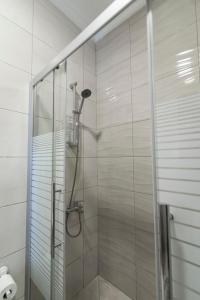 een douche met een glazen deur in de badkamer bij Jubeiha View Apartments in Amman