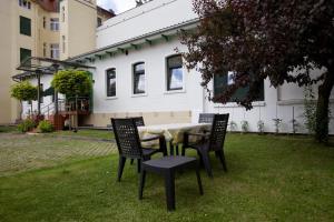 einen Tisch und Stühle im Hof eines Hauses in der Unterkunft Zum Grünen Tor - ganzheitliche Pension in Görlitz