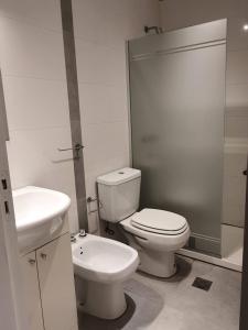 a white bathroom with a toilet and a sink at Apartamento Deluxe Senderos del Vino IV, Desayuno Opcional in Mendoza +49 photos