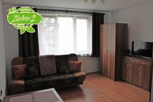 a living room with a couch and a television at Apartament Zielna 2 in Stegna