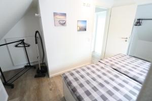 1 dormitorio con 1 cama con manta a cuadros en Appartementhaus-Kogge-Wohnung-12, en Cuxhaven