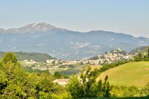 una pequeña ciudad en un valle con montañas en el fondo en I Bócci, en Castel dʼAiano