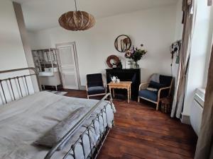 a bedroom with a bed and a table and chairs at Le Brasseur Logements in Saint-Caprais
