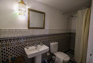 uma casa de banho com um lavatório, um WC e um espelho. em Riad Arabella em Fez