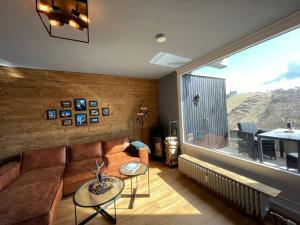 a living room with a couch and a large window at Harzchalet Emma 2 in Sankt Andreasberg
