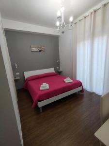 1 dormitorio con cama roja y manta roja en Desidora B&B, en Mirabella Eclano