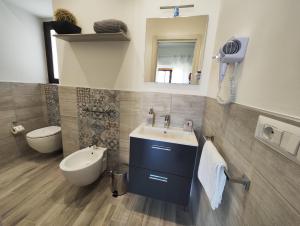 W łazience znajduje się umywalka, toaleta i lustro. w obiekcie B&B CESARE'S Guests w mieście Aci Trezza