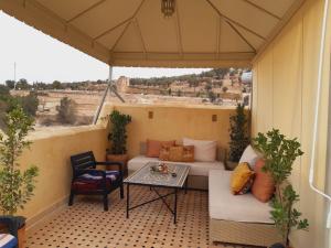 a patio with a couch and a table on a balcony at Riad Arabella in Fez