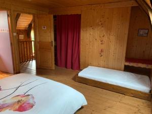 een slaapkamer met 2 bedden en een rood gordijn bij LA RUCHE in Mauriac