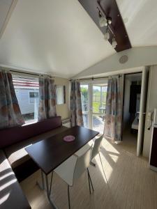 a living room with a table and a couch at Team Holiday - Camping du Petit Pont in Arvert