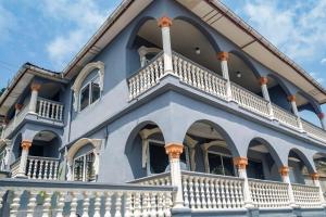 a blue and white house with white balconies at M & B Residence in Freetown