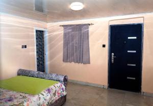 a room with a couch and a black door at M & B Residence in Freetown