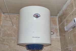 a white water heater in the corner of a bathroom at M & B Residence in Freetown +12 photos