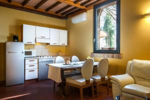a kitchen with a table and chairs and a refrigerator at Fattoria San Lorenzo in Grosseto
