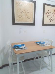 mesa de comedor con 2 sillas blancas en Flat a beira mar, vista lateral - Araça 408, en Natal