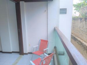 una silla roja sentada en un lateral de un edificio en Flat a beira mar, vista lateral - Araça 408, en Natal