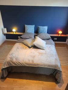 1 cama grande en una habitación con 2 lámparas en las mesas en maison de vacances locquirec en Locquirec