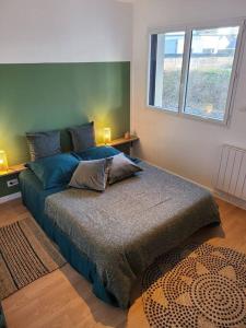 1 dormitorio con 1 cama con 2 almohadas en maison de vacances locquirec en Locquirec