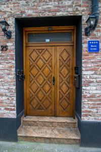 uma porta de madeira ao lado de um edifício de tijolos em Rooms BAUMAN em Osijek