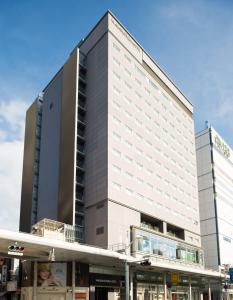 ein großes weißes Gebäude mit einem Einkaufszentrum in der Unterkunft Hiroshima Washington Hotel in Hiroshima