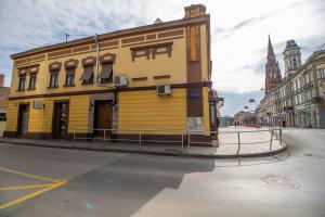 un edificio amarillo en la esquina de una calle en Rooms BAUMAN en Osijek