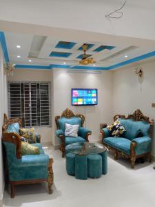 a living room with blue chairs and a table at Stunning 1-Bed Apartment in Dhaka close to airport in Dhaka