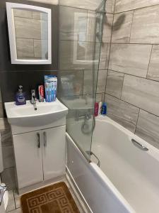 a bathroom with a tub and a sink and a shower at Ground Floor One Bedroom Bayswater Central London in London