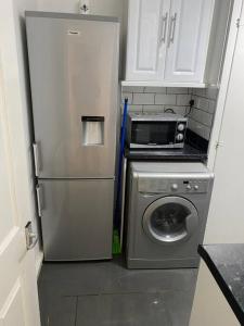 a kitchen with a refrigerator and a washing machine at Ground Floor One Bedroom Bayswater Central London in London