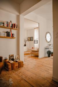 een woonkamer met witte muren en houten vloeren bij Maison 15 in Sauternes