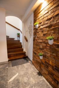 ceglana ściana w korytarzu z doniczkami w obiekcie Rooms BAUMAN w mieście Osijek