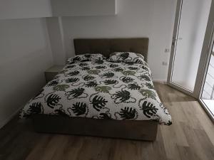 łóżko z czarno-białą kołdrą w sypialni w obiekcie SABOTINO APARTMENT w mieście Civitanova Marche