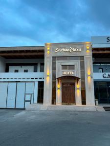 un edificio de hotel con un cartel que dice palacio sunoco en Sarbon Plaza Hotel, en Bukhara