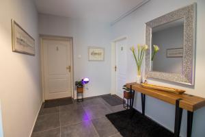 um corredor com um espelho e piso em azulejo em Rooms BAUMAN em Osijek
