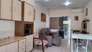uma cozinha e sala de estar com um sofá e uma mesa em Studios prox Cataratas e Aduana Argentina em Foz do Iguaçu