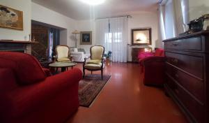 un soggiorno con divano rosso e sedie di B&B Parco degli Ulivi a Misano Adriatico