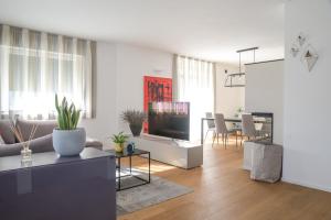 un soggiorno con divano e TV di Casa Riccardo a Levico Terme