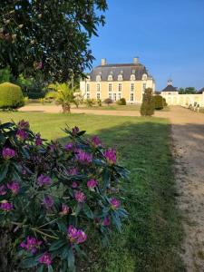 a large house with pink flowers in front of it at Château du Boschet chambre de l’infatigable gentilhomme in Bourg-des-Comptes