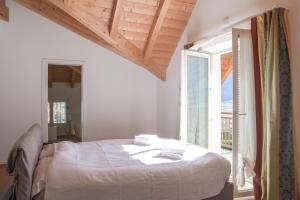 a bedroom with a bed and a large window at Casa Riccardo in Levico Terme