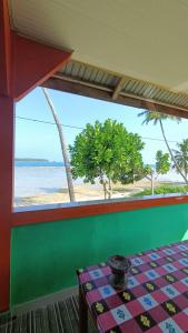 a room with a table and a view of the beach at Aloha Guest House Nias in Hilibotodane