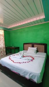 ein Schlafzimmer mit einem Bett mit roten Blumen darauf in der Unterkunft Aloha Guest House Nias in Hilibotodane