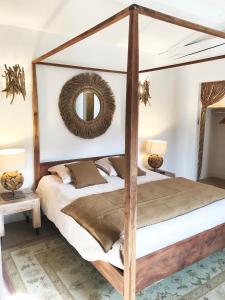a bedroom with a four poster bed and a mirror at Bastide Nomade - Charming B&B in Saint-Paul-de-Vence