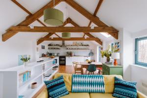 a living room with a couch and a table at The Red Barn at Venn Farm - Gorgeous Upside-Down Barn on Smallholding Near Cornish Surf Beaches in Bude