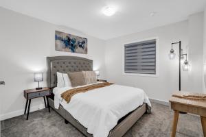 een witte slaapkamer met een bed en een raam bij Lavish Home on Scenic Mountain - King Bed in Hamilton