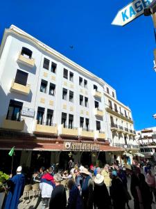 a crowd of people standing in front of a building at Hotel Mauritania in Tangier